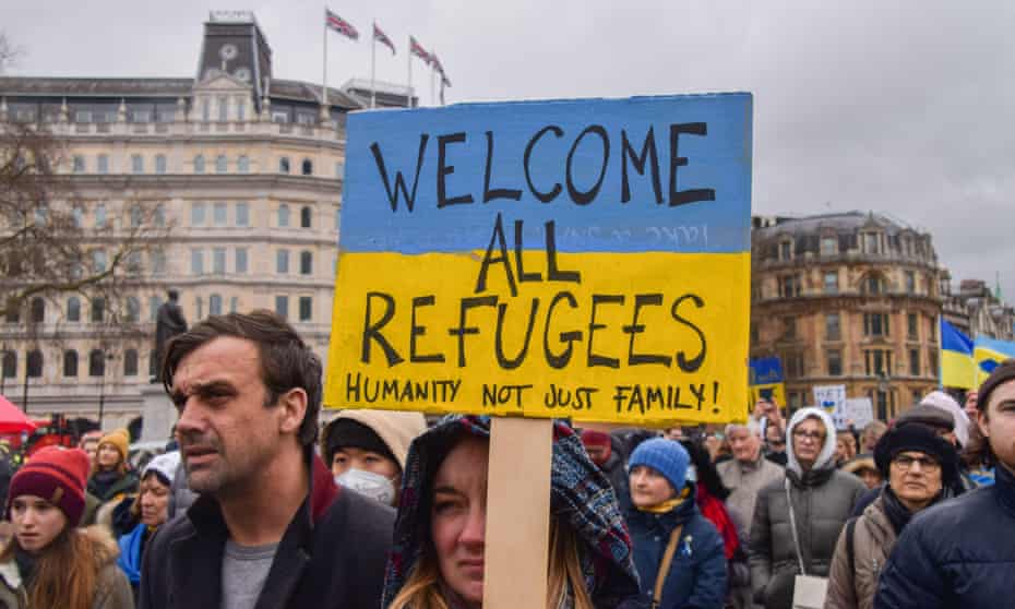 A protester holds a 'Welcome All Refugees' placard. Thousands of people gathered in Trafalgar Square