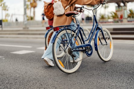 Cropped picture of people crossing crosswalk on the street with bikes.