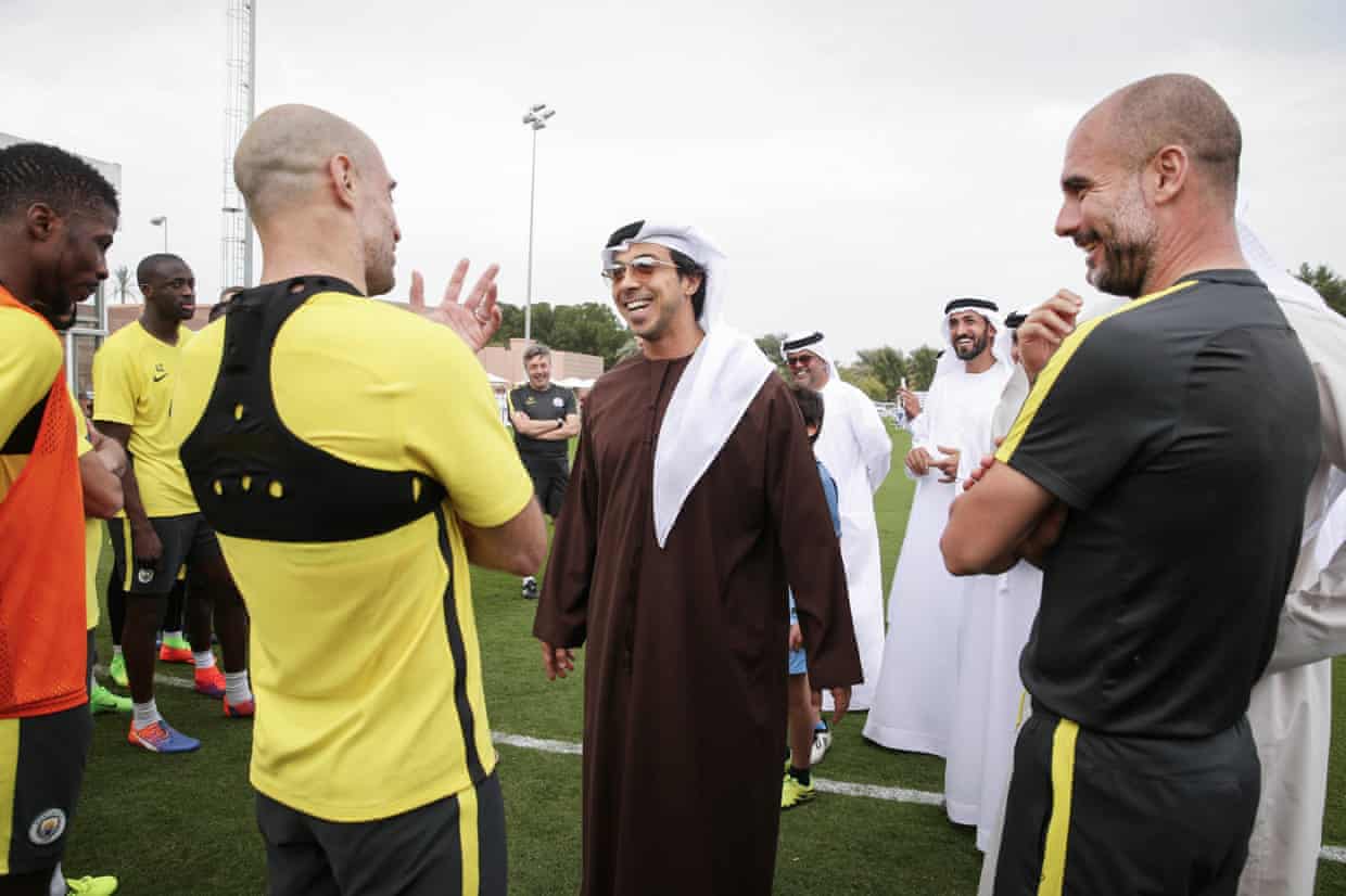 Sheikh Mansour laughs chatting with Pablo Zabaleta and Pep Guardiola on a training pitch