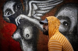 Artist Yuriel P poses by his mural titled El Miedo a la Salvacion, or Fear of Salvation, in Havana