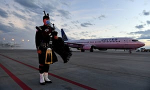 Aurora, Colorado firefighter Tom Johnson stands at attention as the United Airlines flight carrying the body of retired paramedic Paul Cary arrives at Denver International Airport on Sunday.