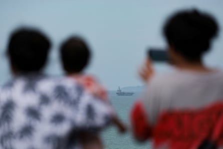 people recording a ship on their phone