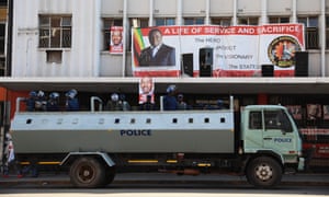 Police officers guard the headquarters of the opposition Movement for Democratic Change party