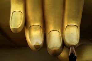 Ang Thon, Thailand
A woman prays while touching the fingers of a statue of Buddha during the annual Makha Bucha day.