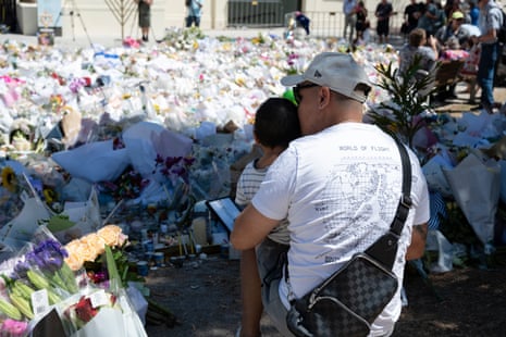 People attend a floral tribute outside the Bondi Pavilion honouring victims of the Hanukah terror attack on Sunday.