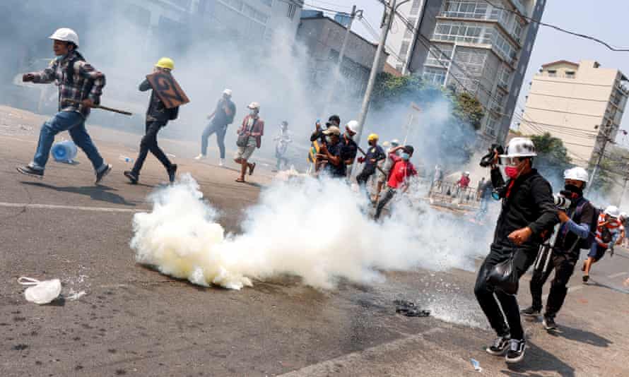 Protesters run away from security forces in Yangon