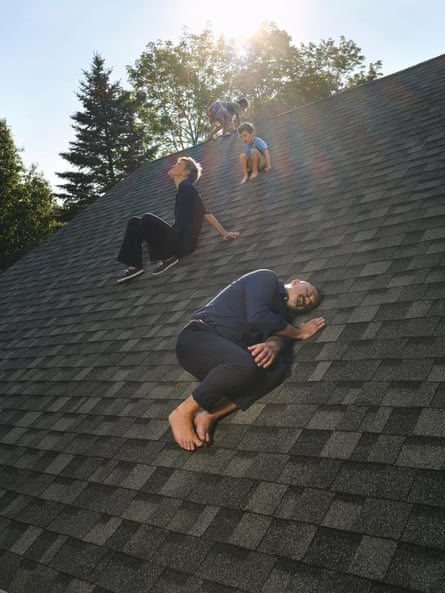 The couple with their two children, photographed at home. They are all on a sloping roof