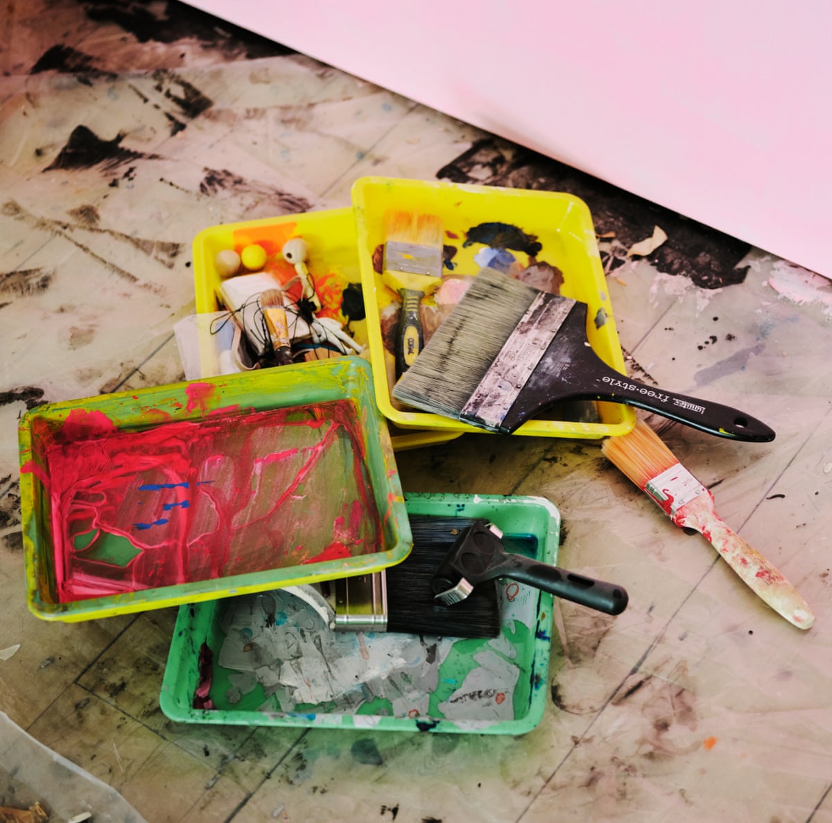 A pile of trays of paint and paintbrushes