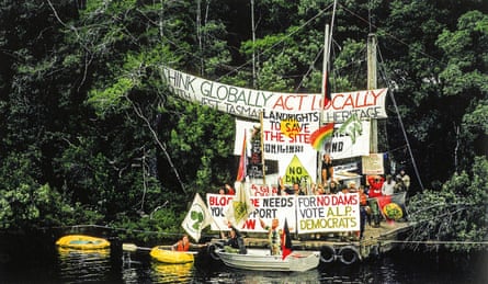 A protest site covered in banners beside the river
