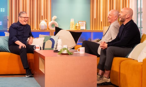Keir Starmer laughing on TV talkshow sofa with Tim Lovejoy and Simon Rimmer