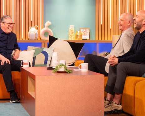 Keir Starmer laughing on TV talkshow sofa with Tim Lovejoy and Simon Rimmer
