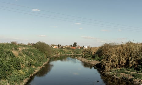 Under a blue sky with only a couple of clouds, the Reconquista river stretches into the distance.
