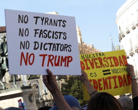 A sign reading 'No Trump' is held aloft at a protest in Madrid