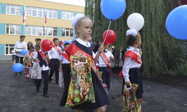 Childern take part in a ceremony marking the start of classes at a school in Mariupol, Ukraine