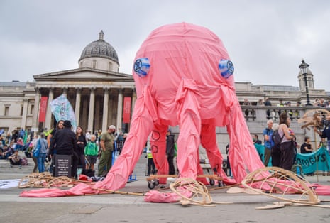 Protests stand by a model pink octopus in Trafalgar Square, London.