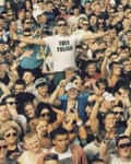 A man in a Free Tulisa T-shirt, arms outspread, in the crowd at a music festival