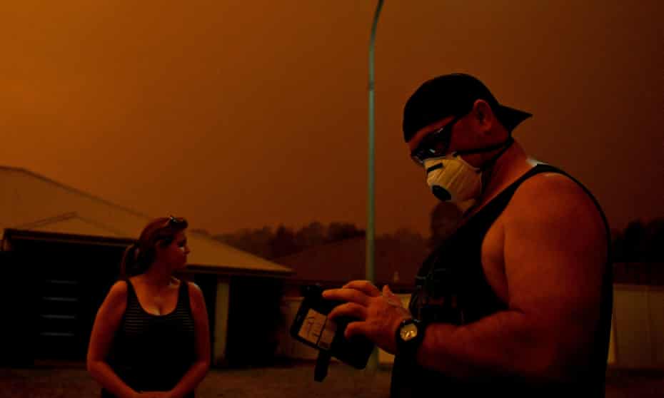 Man using mobile phone in Nowra amid smoke from bushfire