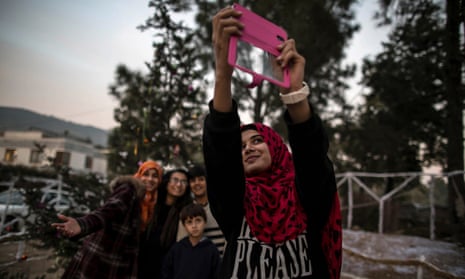 Young Muslims take a selfie in front of a Christmas tree in a Christian slum in Islamabad, Pakistan.