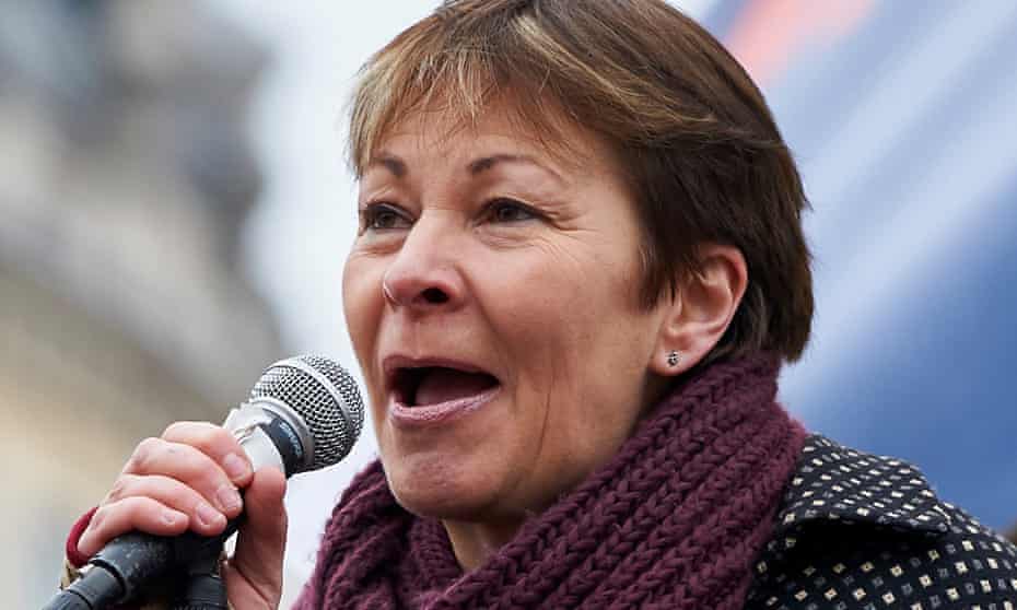 Caroline Lucas with microphone in hand addresses an outdoor rally
