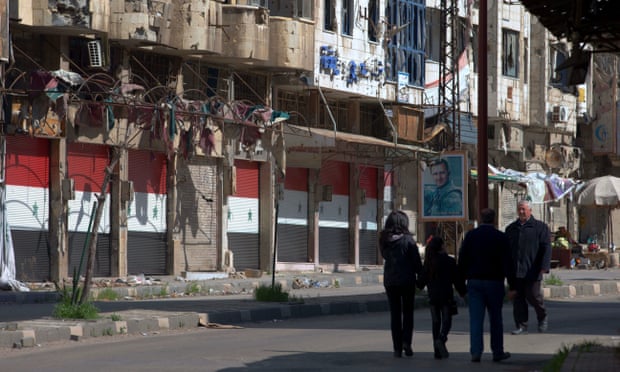 Citizens walk through a devastated part of the old city of Homs, Syria, on Friday.