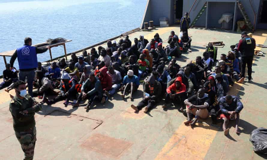 Migrants sit aboard a Libyan coastguard vessel arriving at the capital Tripoli’s naval base on February 28, 2021.
