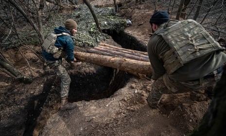 Ukrainian soldiers place logs to protect their positions at the frontline near Bakhmut.