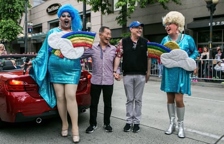 Takei and his husband Brad Altman flanked by two tall drag queens in sparkly turquoise dresses at the Seattle Pride parade in 2014.