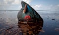 A hard hat from an oil worker lies in oil from the Deepwater Horizon oil disaster on East Grand Terre Island, Louisiana June 8, 2010.