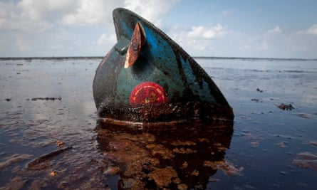 An oil worker’s hard hat lies in oil from the 2010 Deepwater Horizon disaster.