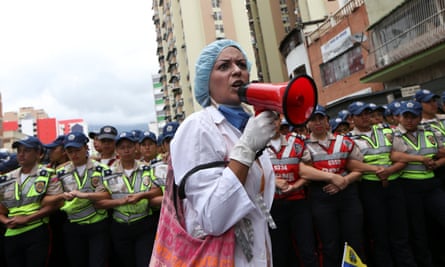 A woman shouts slogans in front of the riot polices during a rally of health sector workers in Caracas.