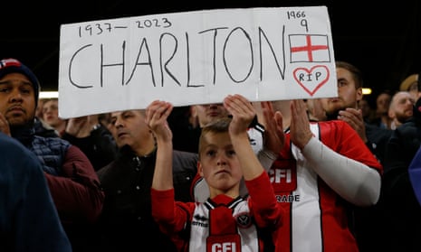 A young Sheffield United fan displays a Bobby Charlton banner in the stands before the match following his passing.
