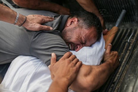 A man mourns over the body of a relativ at a morgue in Al-Aqsa Martyrs hospital.