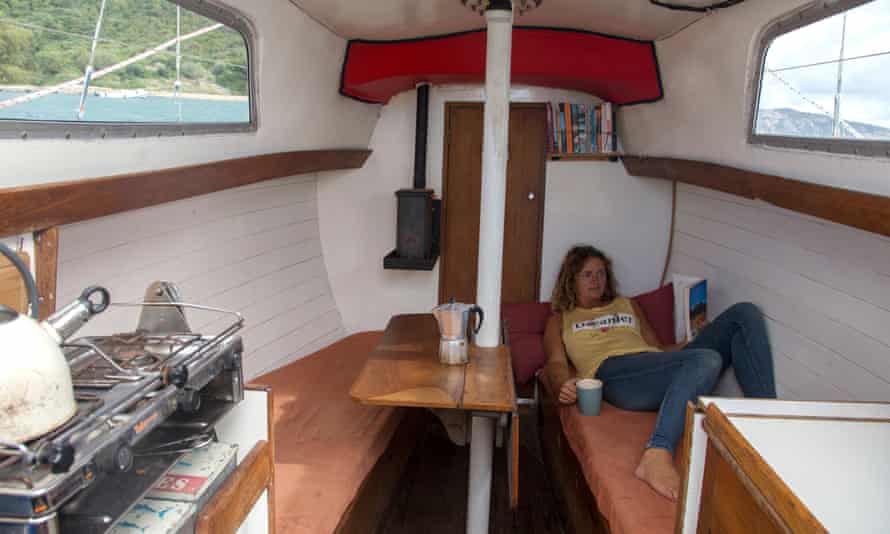 Susan Smillie reading a book, lying in the cabin of her boat