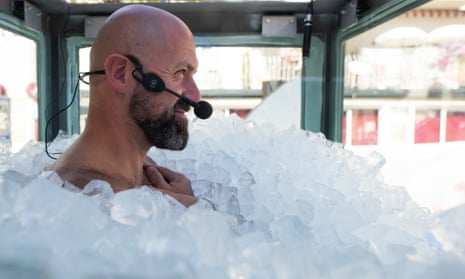 Josef Koeberl stands in a glass box filled with ice