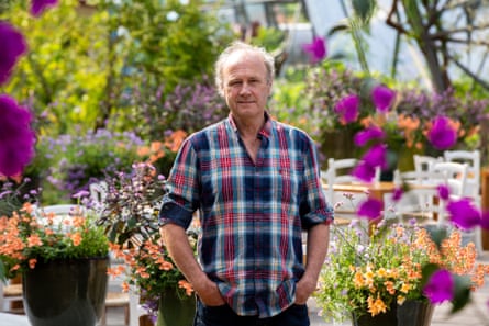 Tim Smit at the Eden Project with colourful flowers in the background