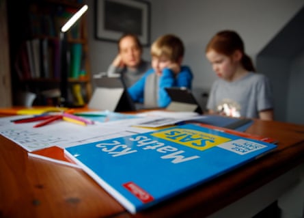 A woman helping her children with home schooling