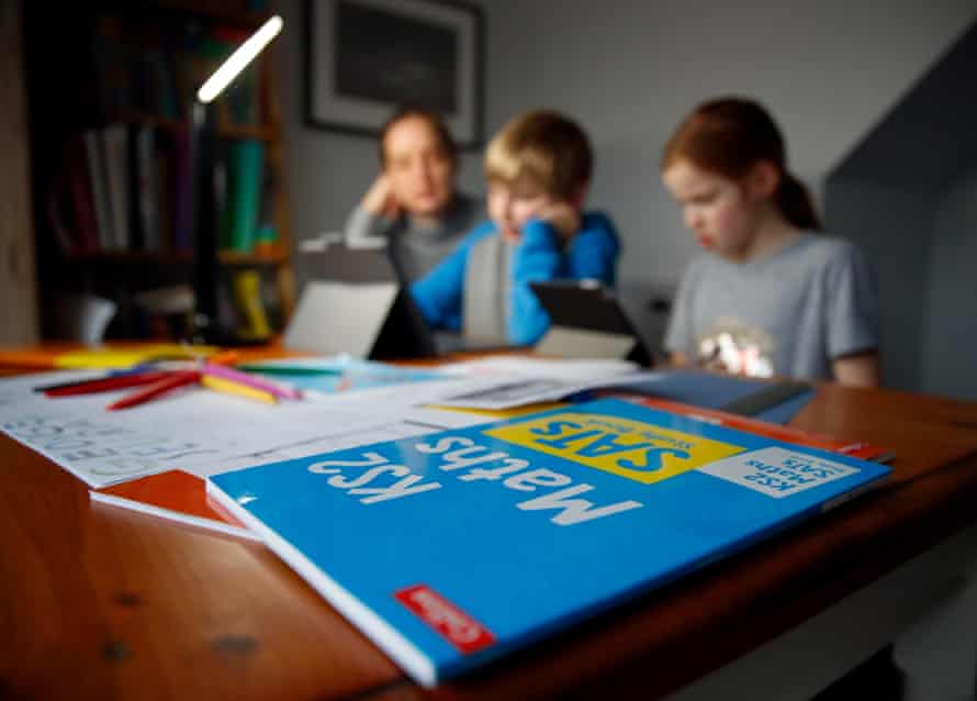 A woman helping her children with home schooling