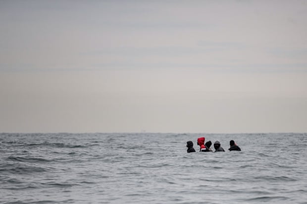 Migrants in a small boat off Sangatte, France, as they try to cross the Channel.
