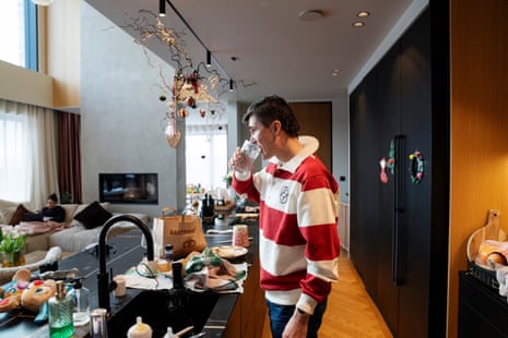 Jakob Ingebrigtsen drinking a glass of water at home with his wife, Elisabeth Asserson, in the background.