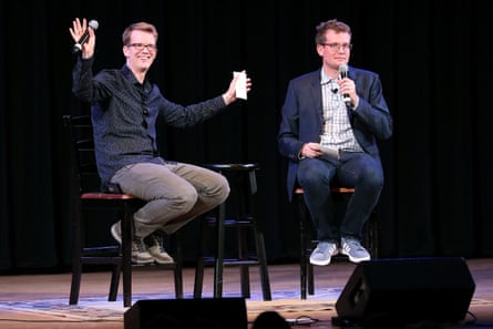 Two men sitting on a stage holding microphones for an interview