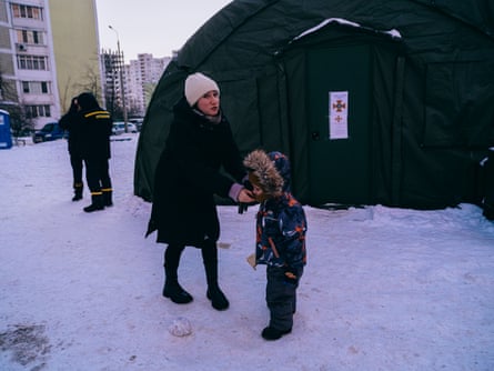Natalia and her son Danylo in the snow outside the tent