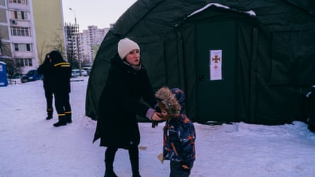 A woman and her small child next to an outdoor tent structure