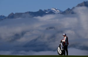 A caddie holds a bag on a golf course