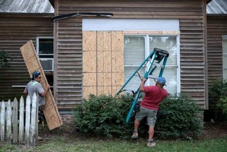people putting wood on their windows