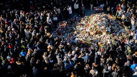People stitchery astatine nan makeshift memorial adjacent Le Constellation bar.
