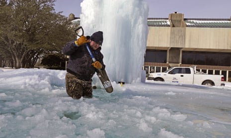 Kaleb Love, a municipal worker, breaks ice on a frozen fountain in Richardson, Texas, on Tuesday, as freezing temperatures grip the state.