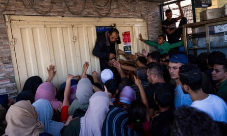 Palestinians crowd around a bakery in Gaza