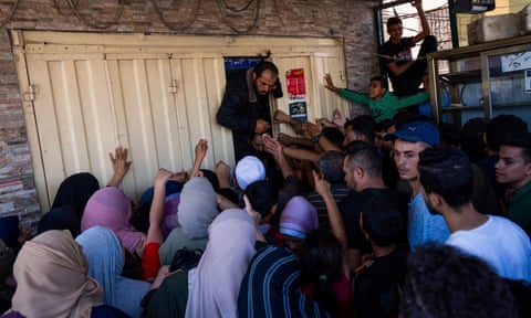 Palestinians crowd around a bakery in Gaza