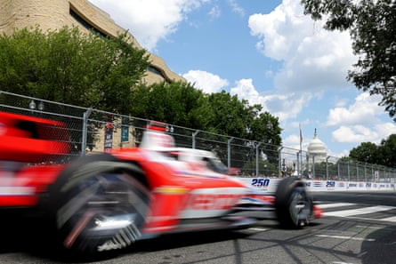 red and white car speeds by on street