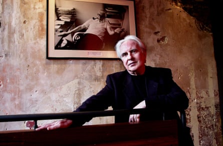 Peter Gill at the Royal Court theatre, London, with a photograph of George Devine on the wall.